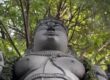 Garlanded stone deity statue beneath tree canopy at Sri Narayani Peedam, Vellore, Tamil Nadu